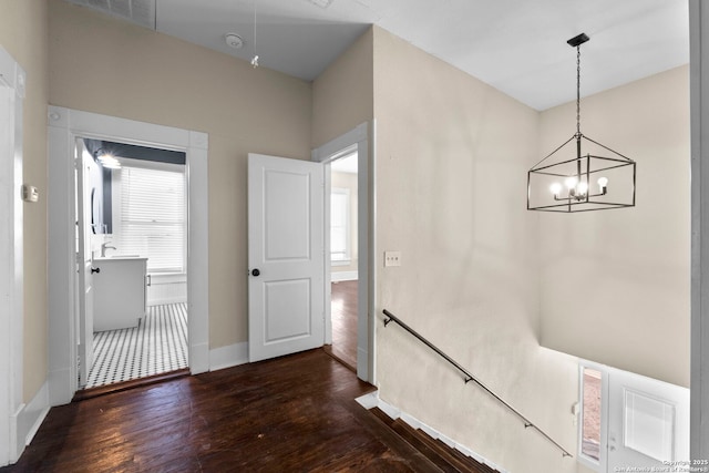 hall featuring dark hardwood / wood-style floors and a chandelier