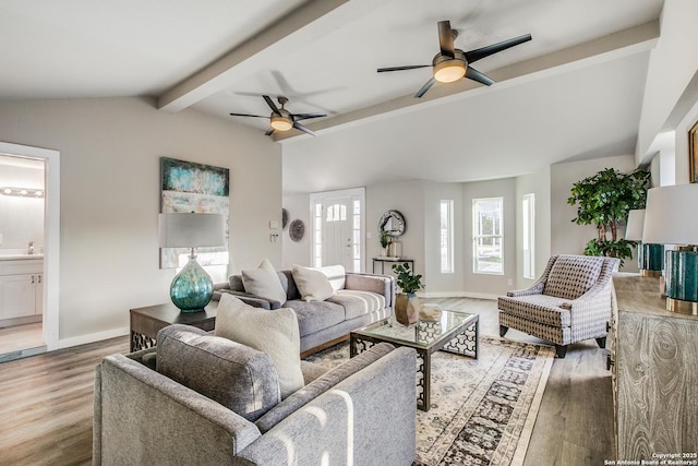 living room with ceiling fan, sink, hardwood / wood-style floors, and vaulted ceiling with beams