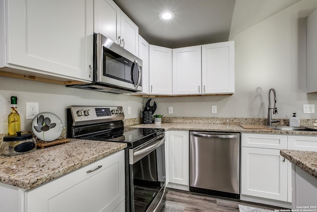 kitchen featuring light stone counters, sink, white cabinets, and appliances with stainless steel finishes