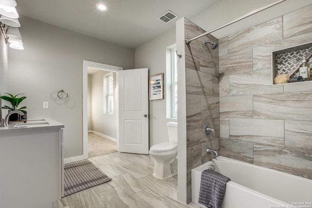 full bathroom with tiled shower / bath combo, vanity, and toilet