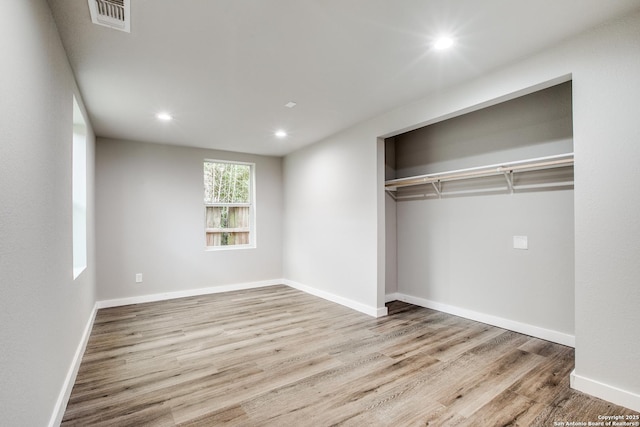 unfurnished bedroom with light hardwood / wood-style floors and a closet