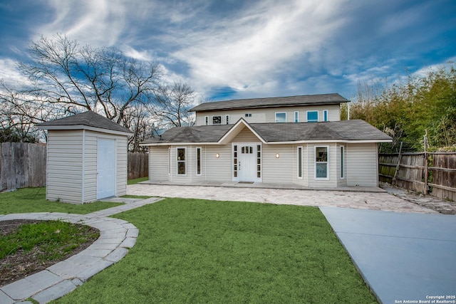 view of front facade with a shed, a front yard, and a patio