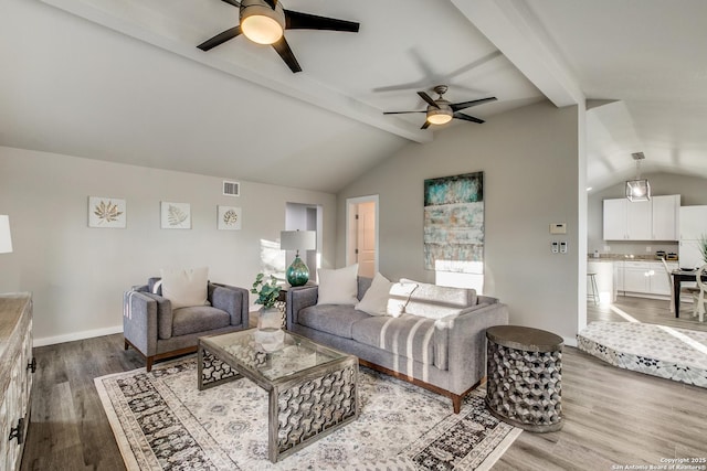 living room featuring wood-type flooring, vaulted ceiling with beams, and ceiling fan