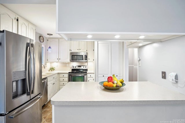 kitchen featuring light tile patterned floors, sink, stainless steel appliances, white cabinets, and decorative light fixtures