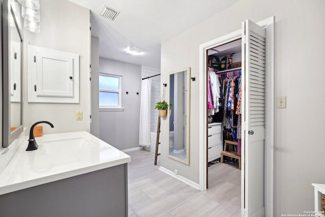 bathroom featuring vanity, hardwood / wood-style floors, and walk in shower