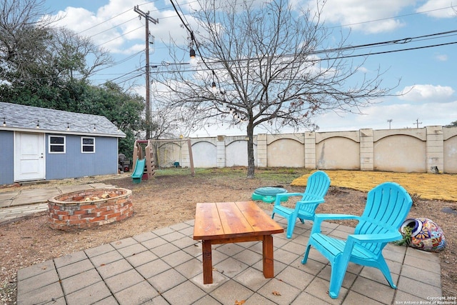 view of patio with a fire pit and an outdoor structure