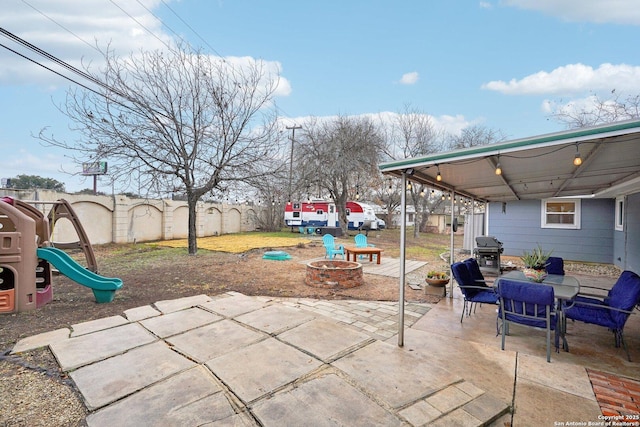 view of patio / terrace featuring area for grilling, a playground, and an outdoor fire pit