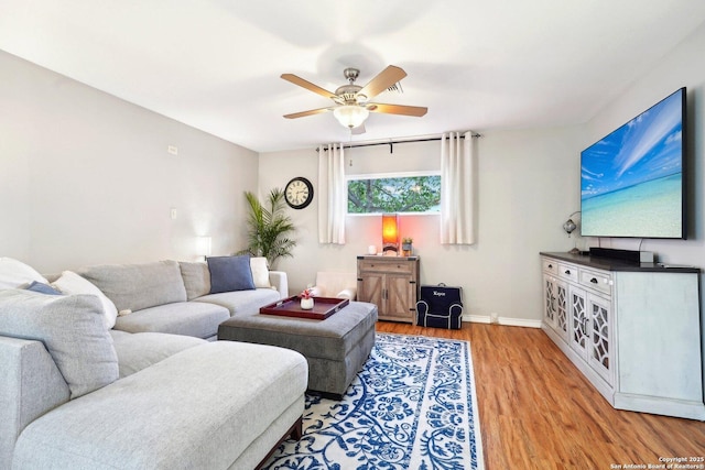 living room featuring ceiling fan and light hardwood / wood-style flooring