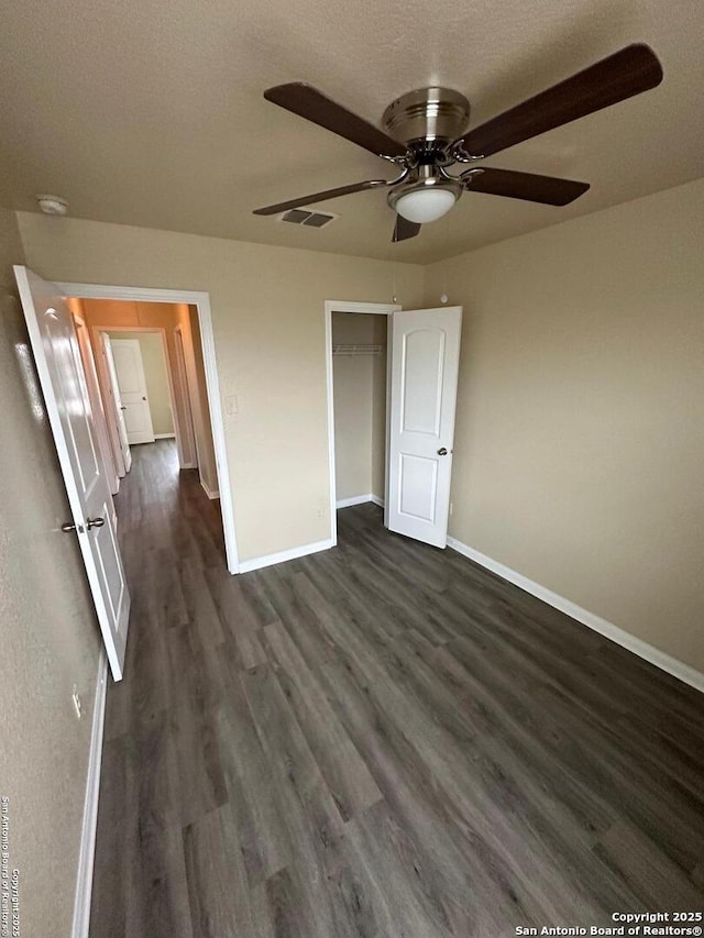 unfurnished bedroom featuring ceiling fan, a textured ceiling, dark hardwood / wood-style flooring, and a closet