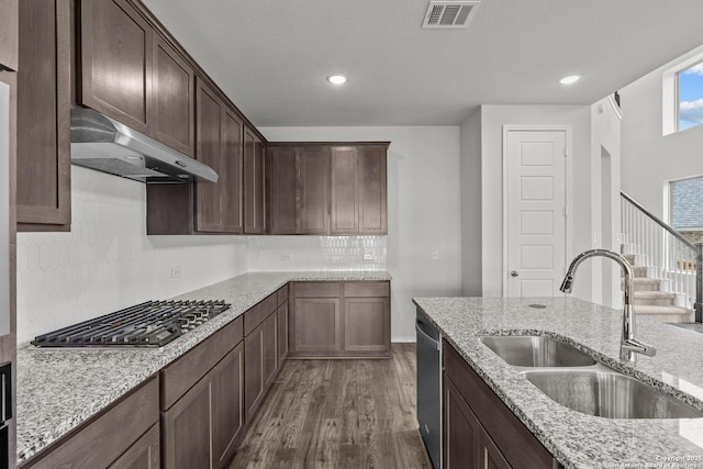 2439 Tinkerton, San Antonio, TX 78245 - kitchen featuring a sink, under cabinet range hood, dark wood finished floors, appliances with stainless steel finishes, and dark brown cabinets