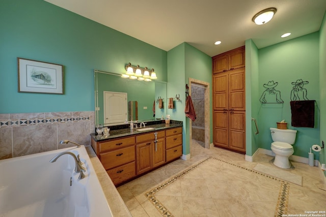 bathroom featuring vanity, tiled tub, tile patterned floors, and toilet