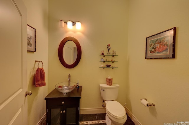 bathroom featuring tile patterned flooring, vanity, and toilet