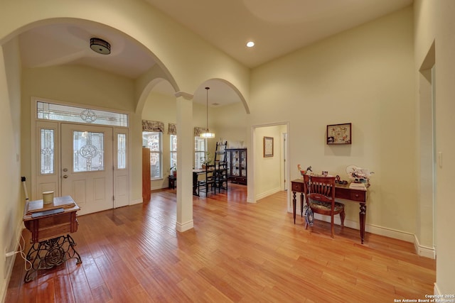 foyer featuring a towering ceiling and light hardwood / wood-style floors