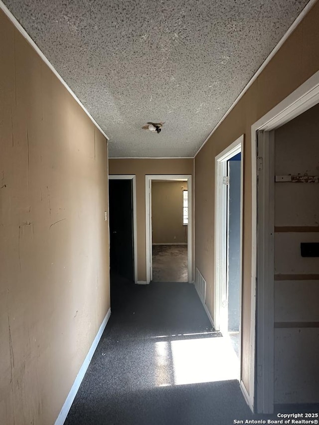 corridor featuring crown molding and a textured ceiling