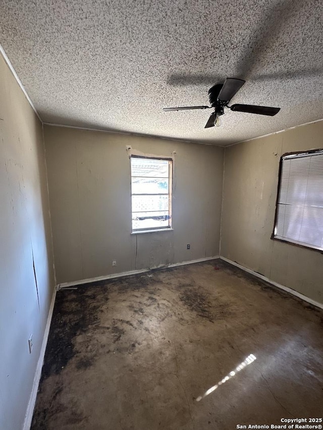 empty room with ceiling fan and a textured ceiling