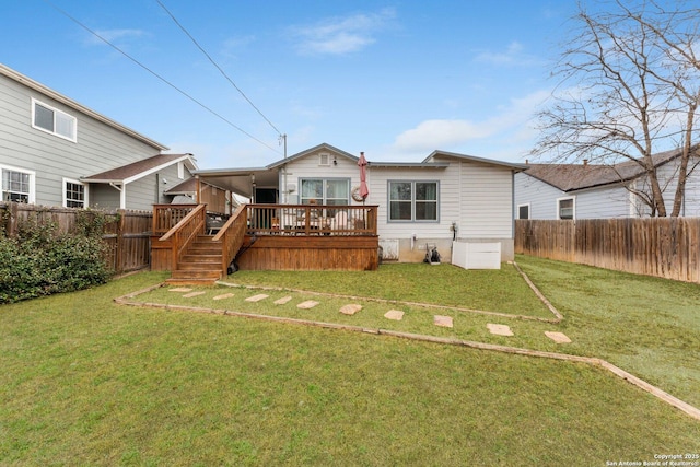 rear view of house with a wooden deck and a lawn