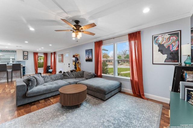 living room featuring hardwood / wood-style flooring, crown molding, and ceiling fan