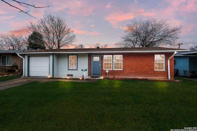 ranch-style home featuring a garage and a lawn