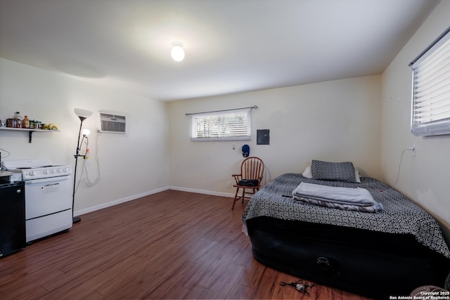 bedroom featuring dark wood-type flooring and a wall unit AC