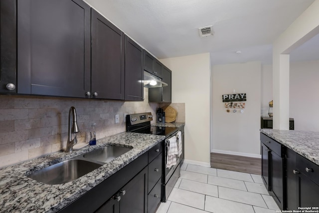 kitchen featuring sink, light stone counters, tasteful backsplash, light tile patterned floors, and stainless steel electric stove