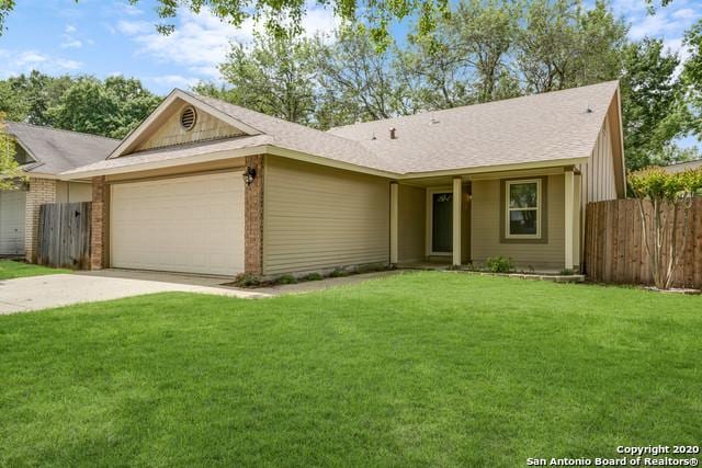 single story home featuring a garage and a front lawn