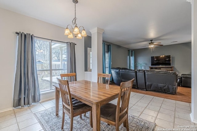 tiled dining area with ceiling fan with notable chandelier and a wealth of natural light