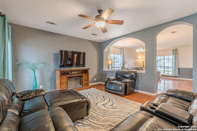 living room with ceiling fan, plenty of natural light, and light wood-type flooring