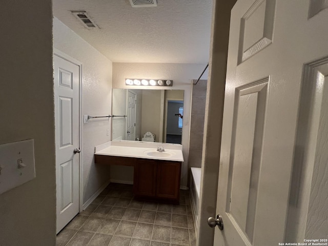 bathroom with vanity, tile patterned flooring, and a textured ceiling