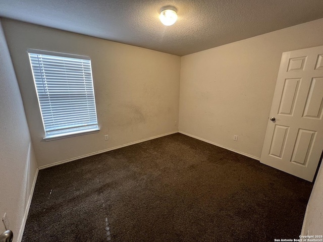 carpeted empty room with a textured ceiling