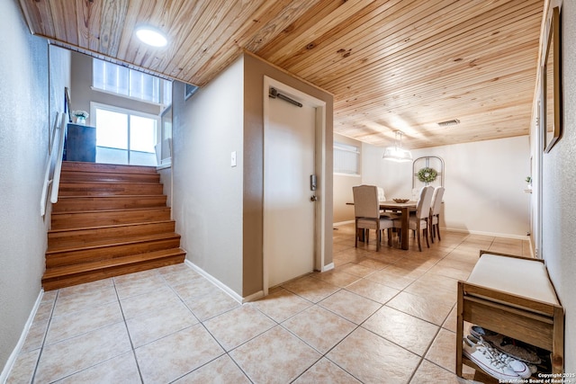 stairway featuring tile patterned flooring and wooden ceiling