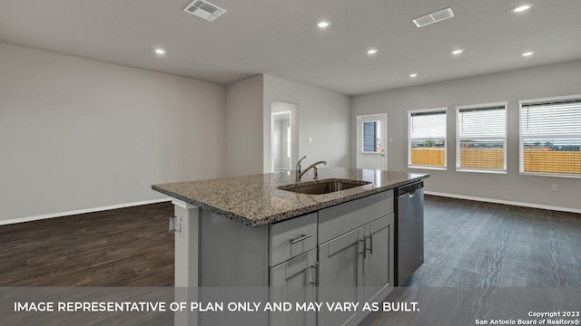 kitchen with stone counters, dark hardwood / wood-style floors, sink, stainless steel dishwasher, and a center island with sink