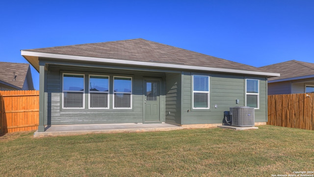 rear view of property with a yard and central AC