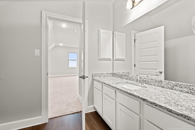 bathroom with vanity, wood-type flooring, and lofted ceiling