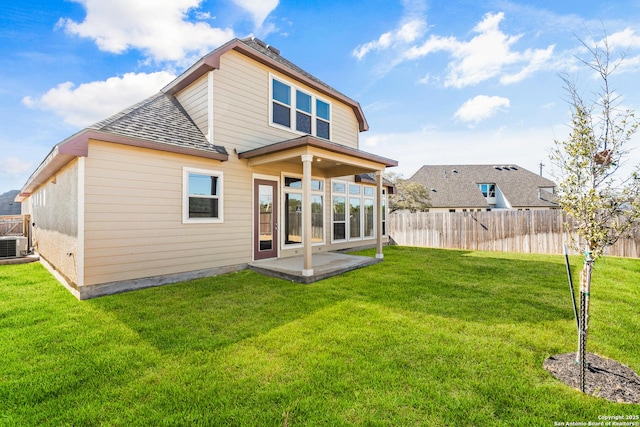 back of house with a patio and a lawn