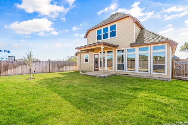 rear view of property with a lawn and a patio