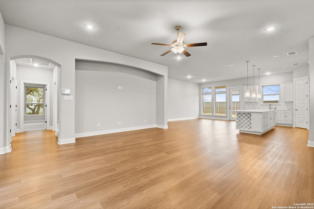 unfurnished living room with light hardwood / wood-style flooring and ceiling fan