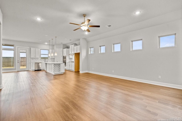 unfurnished living room with ceiling fan and light hardwood / wood-style floors