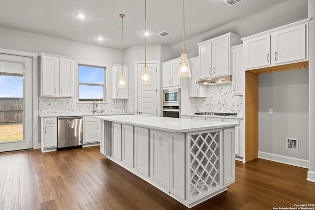 kitchen featuring a kitchen island, sink, white cabinets, hanging light fixtures, and stainless steel appliances