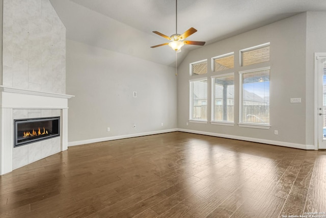 unfurnished living room with ceiling fan, lofted ceiling, a fireplace, and dark hardwood / wood-style flooring