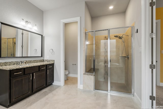 bathroom featuring vanity, tile patterned flooring, a shower with door, and toilet