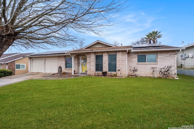 single story home featuring a garage, a front yard, and solar panels