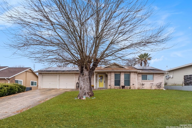 ranch-style house featuring a garage, a front lawn, and solar panels