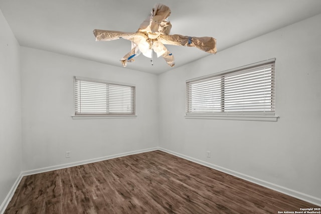 spare room with ceiling fan and dark hardwood / wood-style flooring