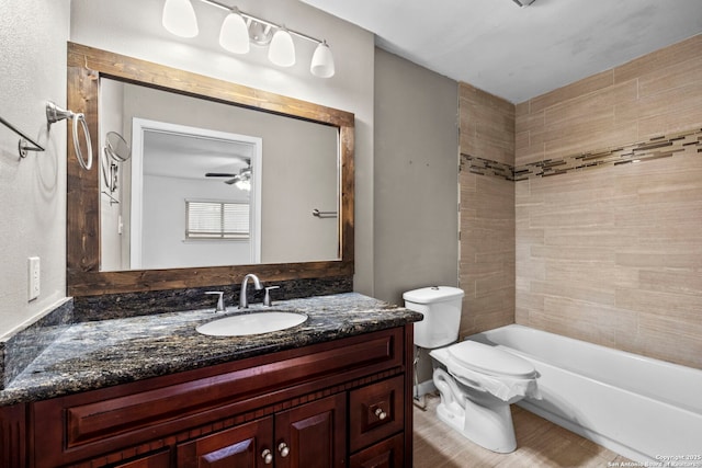 full bathroom featuring tiled shower / bath combo, vanity, and toilet