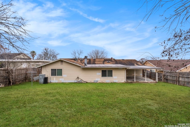 rear view of house with a lawn and a patio