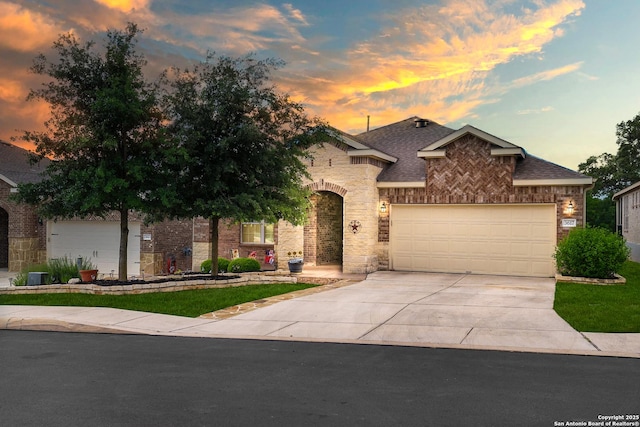 view of front of property with an attached garage, a shingled roof, concrete driveway, and brick siding