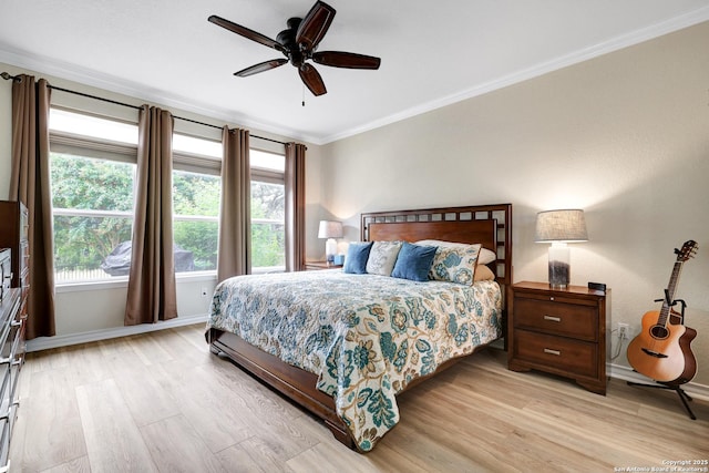 bedroom with light wood finished floors, ceiling fan, ornamental molding, and baseboards