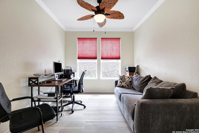 office space featuring a textured wall, ornamental molding, light wood-type flooring, and a ceiling fan