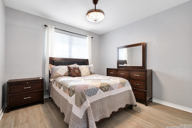 bedroom featuring light wood-type flooring and baseboards