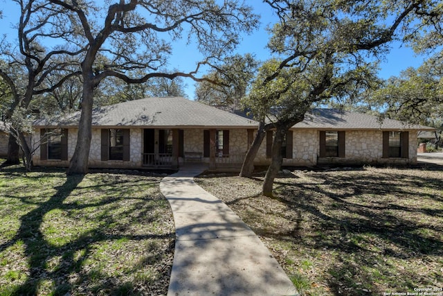 ranch-style house featuring covered porch and a front lawn